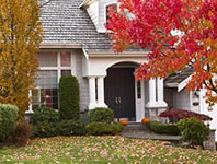 picture of a home with a yard covered in fall leaves