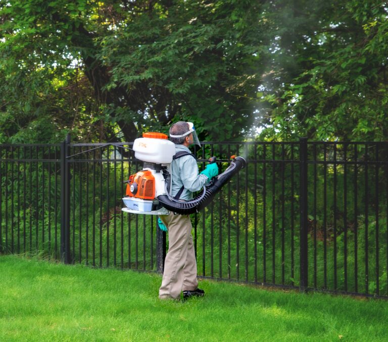 Technician applying mosquito application to woodline.